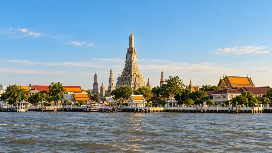 ภาพประกอบ AI พระปรางค์วัดอรุณและอาคารริมแม่น้ำเจ้าพระยาในแสงยามบ่าย