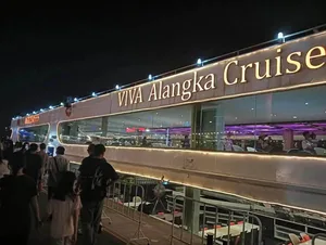 เรือ VIVA Alangka Cruise ประดับไฟจอดเทียบท่ายามค่ำคืน มีผู้โดยสารอยู่บนทางเดิน