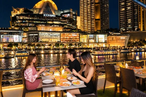 ลูกค้านั่งรับประทานอาหารบน Alangka Cruise โซนดาดฟ้า-ริม พร้อมวิว ICONSIAM ยามค่ำคืนริมแม่น้ำเจ้าพระยา