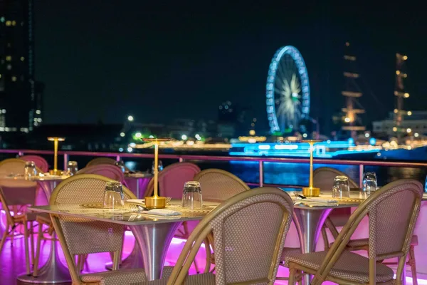 ที่นั่งดาดฟ้าริมระเบียง Super Galaxy Cruise พร้อมวิวแม่น้ำเจ้าพระยาและชิงช้าสวรรค์เอเชียทีคยามค่ำคืน