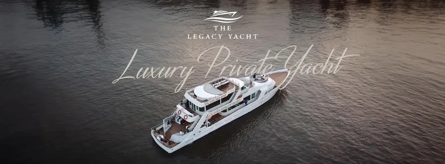 ภาพมุมสูงเรือ The Legacy Yacht กลางแม่น้ำ พร้อมโลโก้และข้อความ Luxury Private Yacht