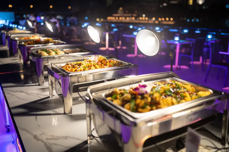 เลือกอิ่มอร่อยกับอาหารร้อนหลากหลายเมนูจากไลน์บุฟเฟต์ของเรือ The Luxury White พร้อมบรรยากาศยามค่ำคืนริมแม่น้ำเจ้าพระยา