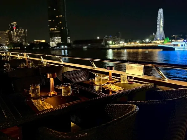 โต๊ะริมดาดฟ้า The Opulence Cruise รอบ Dinner พร้อมโคมไฟสีทอง มองเห็นชิงช้าสวรรค์เอเชียทีคด้านหลัง