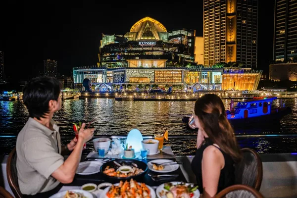โซนดาดฟ้าริม The Planet Cruise พร้อมโต๊ะอาหารและวิว ICONSIAM ริมแม่น้ำเจ้าพระยายามค่ำคืน