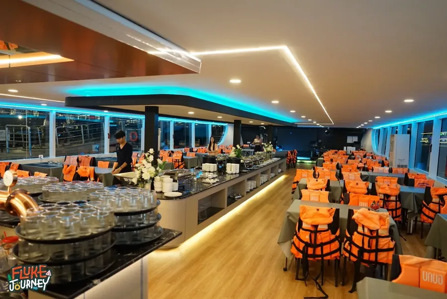 ภายในห้องอาหารปรับอากาศของเรือ Unicorn Cruise จัดโต๊ะที่นั่งเป็นสัดส่วน พร้อมไลน์บุฟเฟต์ตรงกลาง เดินตักอาหารได้สะดวกตลอดการล่องเรือ พร้อมระบบรักษาความปลอดภัยชูชีพสำหรับผู้โดยสารทุกท่าน