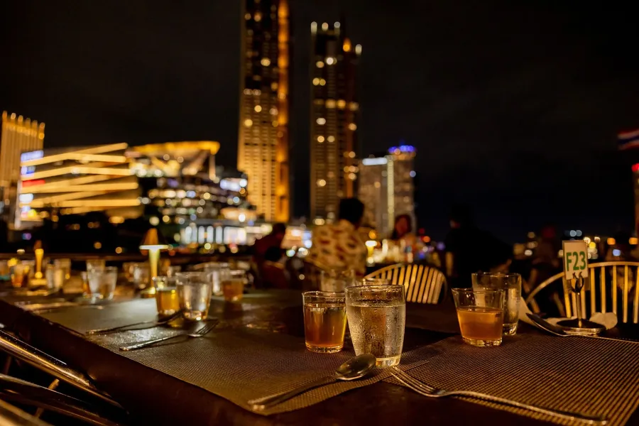 แสงโคมไฟบนโต๊ะและแสงไฟจาก ICONSIAM เติมบรรยากาศอบอุ่นให้มื้อค่ำ เหมาะกับการนั่งพูดคุยและชมวิวไปด้วยกัน