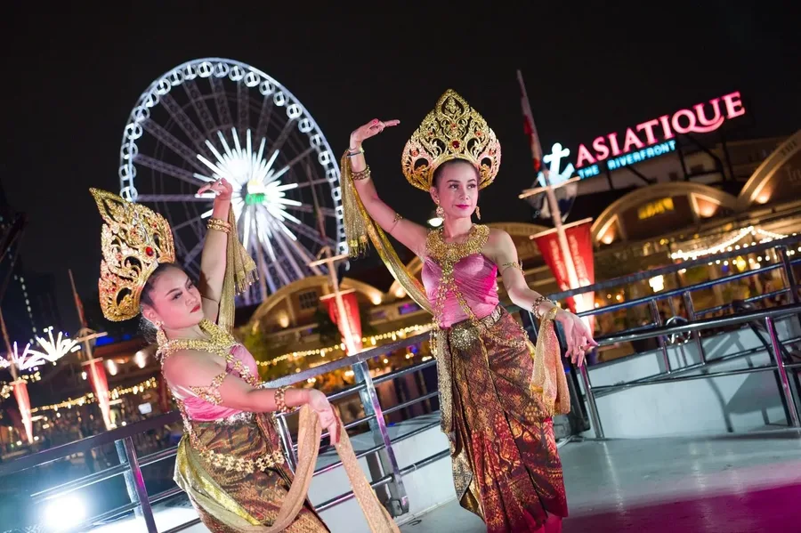 ชมลีลารำในชุดไทยสีชมพูและทอง ท่ามกลางแสงไฟเอเชียทีคและชิงช้าสวรรค์ยามค่ำคืน