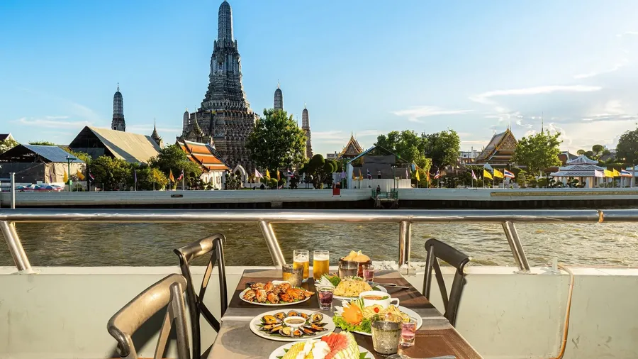 อิ่มกับอาหารหลากหลายที่โต๊ะริมเรือ พร้อมชมวัดอรุณในแสงแดดอุ่น ๆ และรับลมจากแม่น้ำ